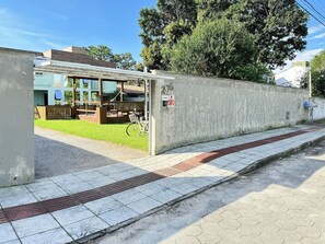 Un bâtiment doté d’un espace extérieur couvert avec des sièges, d’un vélo et d’un mur en béton sur lequel est peint un numéro.