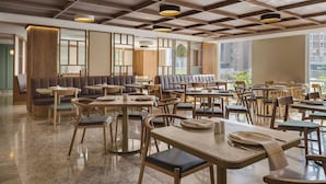 Ein modernes Restaurant mit Holzkubernetes, großen Fenstern und einer karierten Decke.