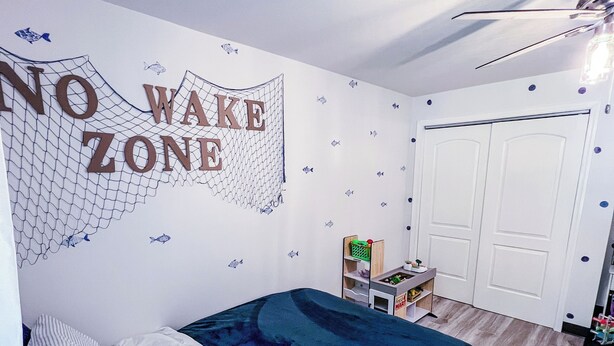A bedroom with a bed, a wardrobe, and a wall with a 'NO WAKE ZONE' sign. - New! Escape at Echo Point with SwimSpa! 2 King Beds-  5 min from boat ramp (Bronston)