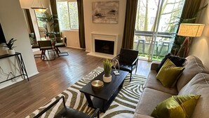 Una sala de estar amplia con chimenea, un comedor y vistas al exterior.