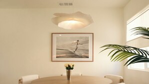 A round wooden dining table with four chairs, a framed picture on the wall, and a hanging light fixture. - Brand new community- Prime Highland Park! Unit 2 (Los Angeles)