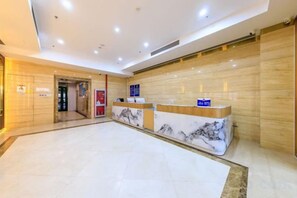 A hotel reception area with marble counters, a wooden reception desk, and a tiled floor. - Zaolinjie (Xuanwu Hospital Store, Niujie Subway Station, Beijing) (Beijing)