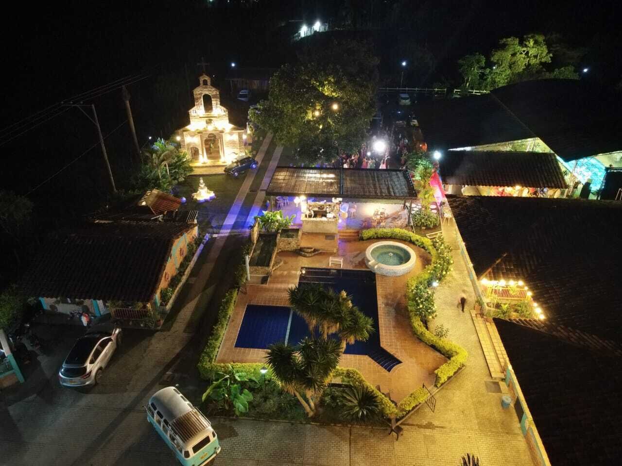 A well-lit outdoor area with a swimming pool, a fountain, and a church-like building.