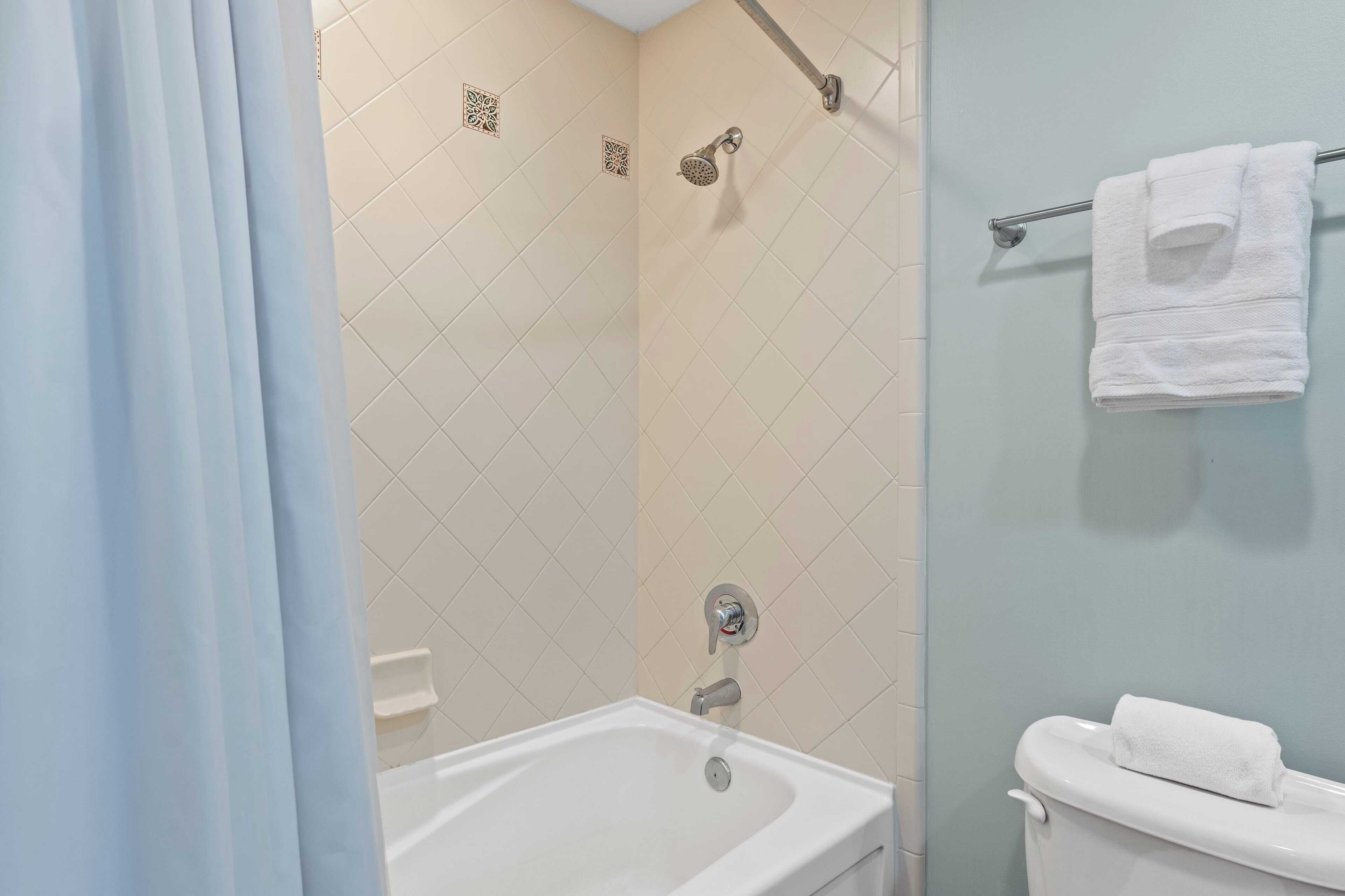 Un baño con bañera, ducha e inodoro.