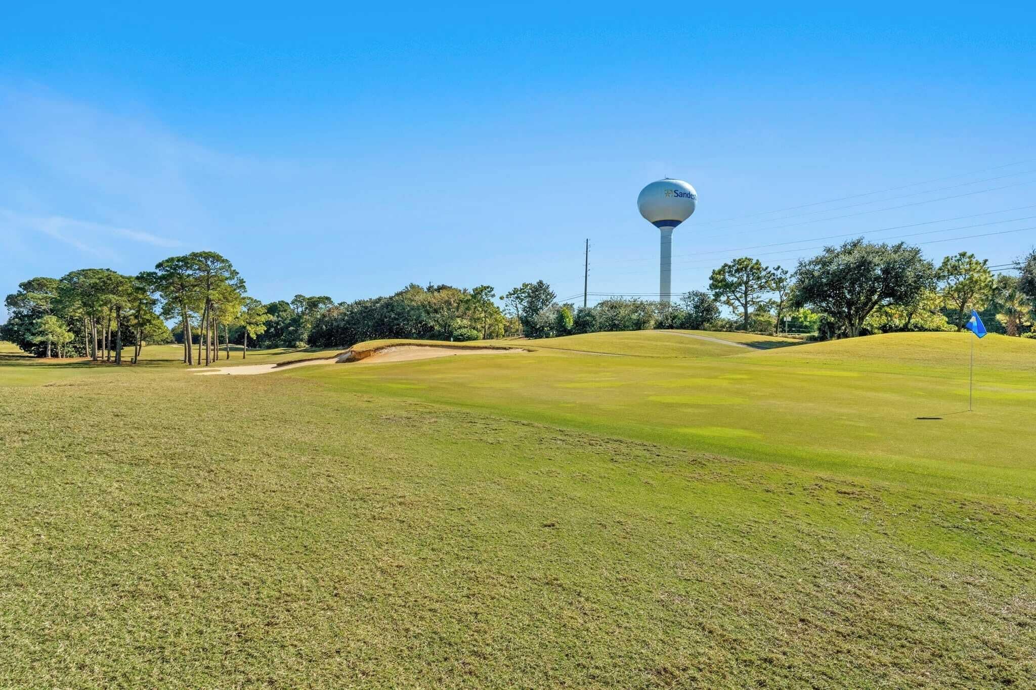 Ein Golfplatz mit einem Wasserturm im Hintergrund.