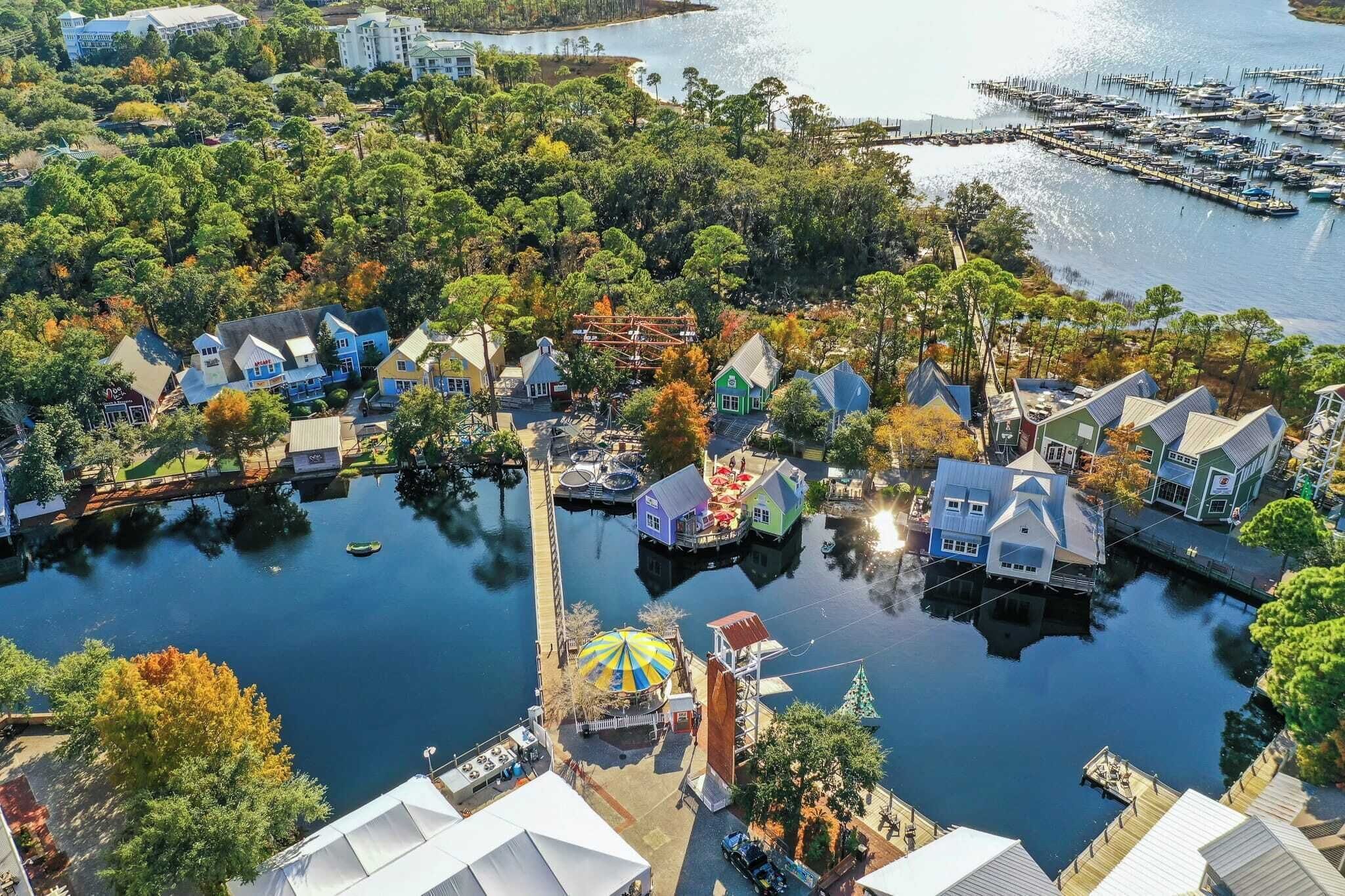 An aerial view of a waterfront area with houses, docks, and a marina.