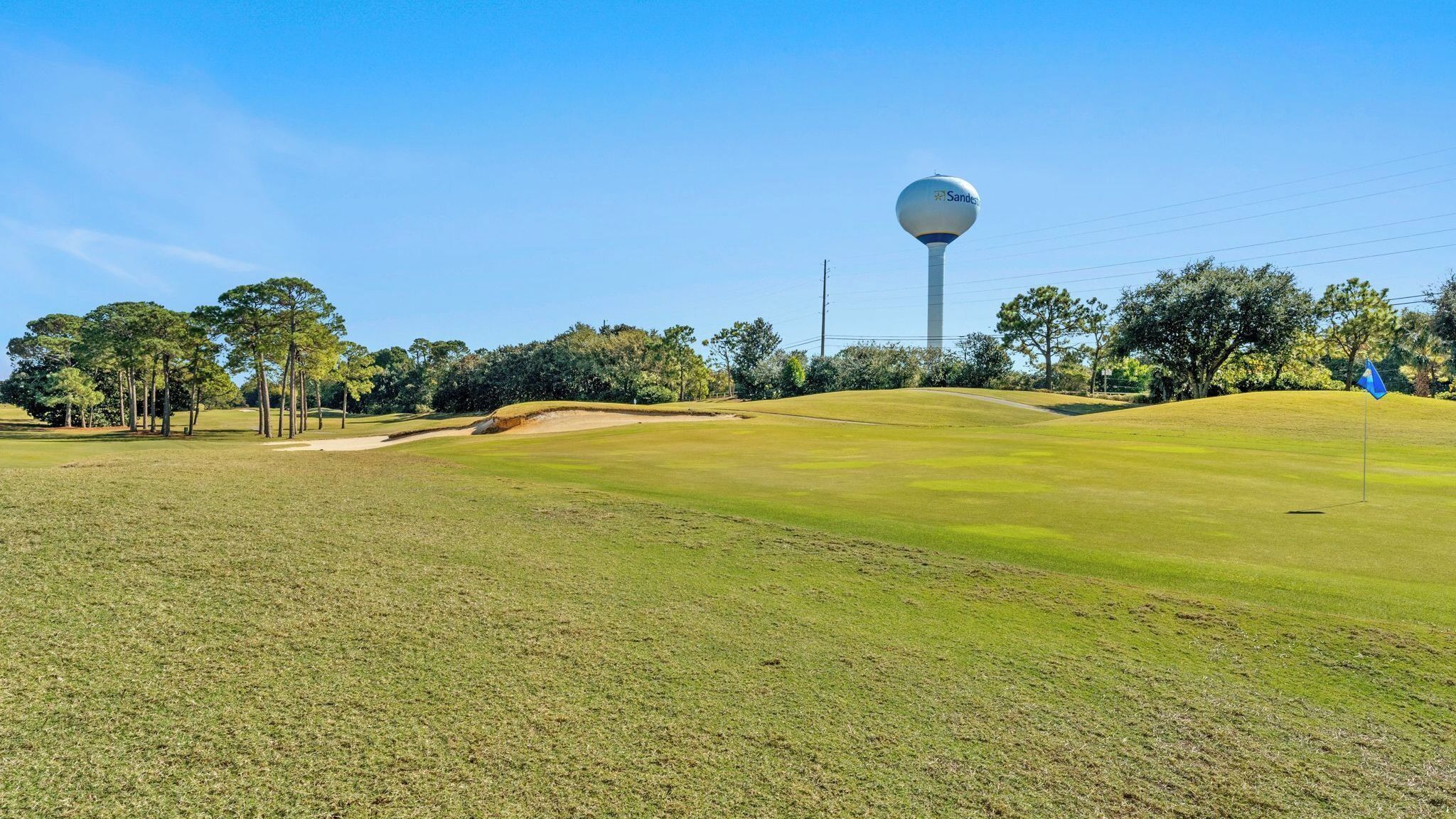 Ein Golfplatz mit einem Wasserturm im Hintergrund.