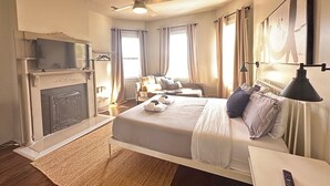 A bedroom with a bed, a ceiling fan, a fireplace, a TV, and a window. - The Historic Darling House + Hot tub in Downtown Savannah!  Great for Groups! (Savannah)
