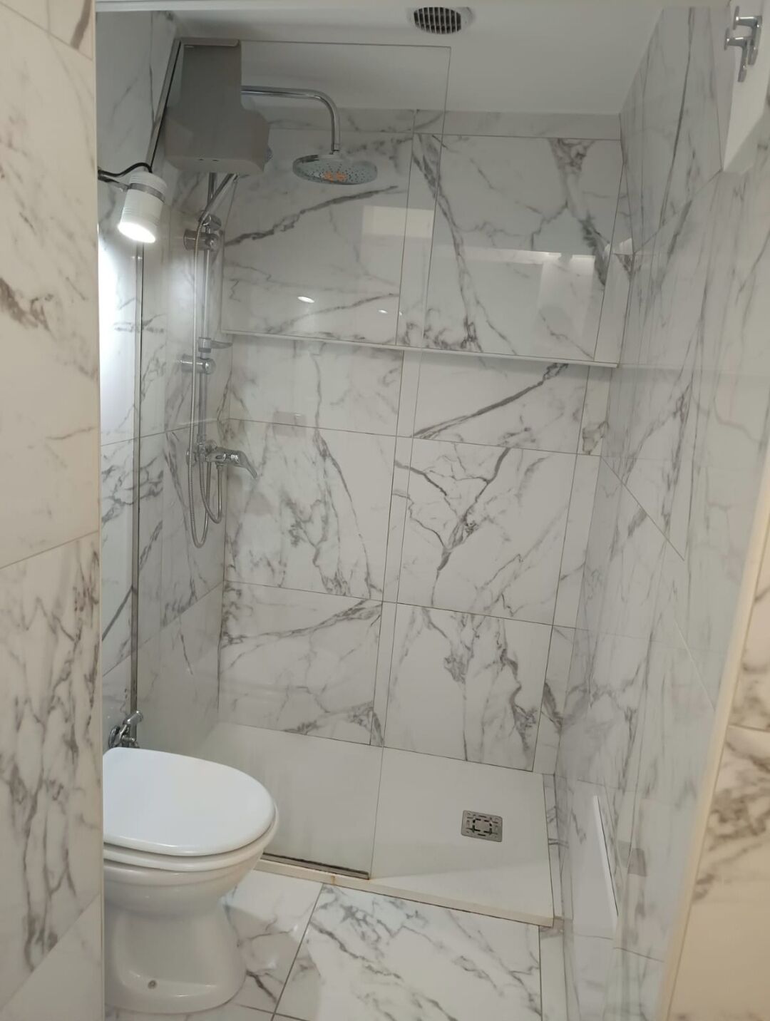 Een douche, een haardroger, een bidet, handdoeken