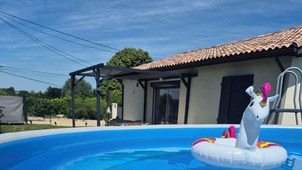 Una piscina con un flotador de unicornio blanco inflable.