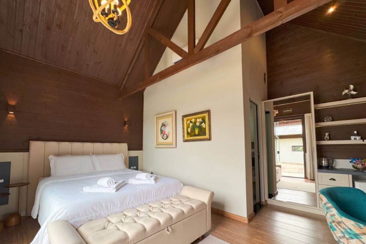 Una camera da letto con un letto grande, un comodino, una panca e vista sull'esterno.