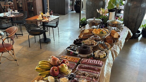 Una mesa de bufé con diferentes alimentos y un área de recepción con sillas y un mostrador.