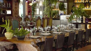 Comedor con una mesa larga dispuesta para varios comensales, rodeado de sillas de mimbre.