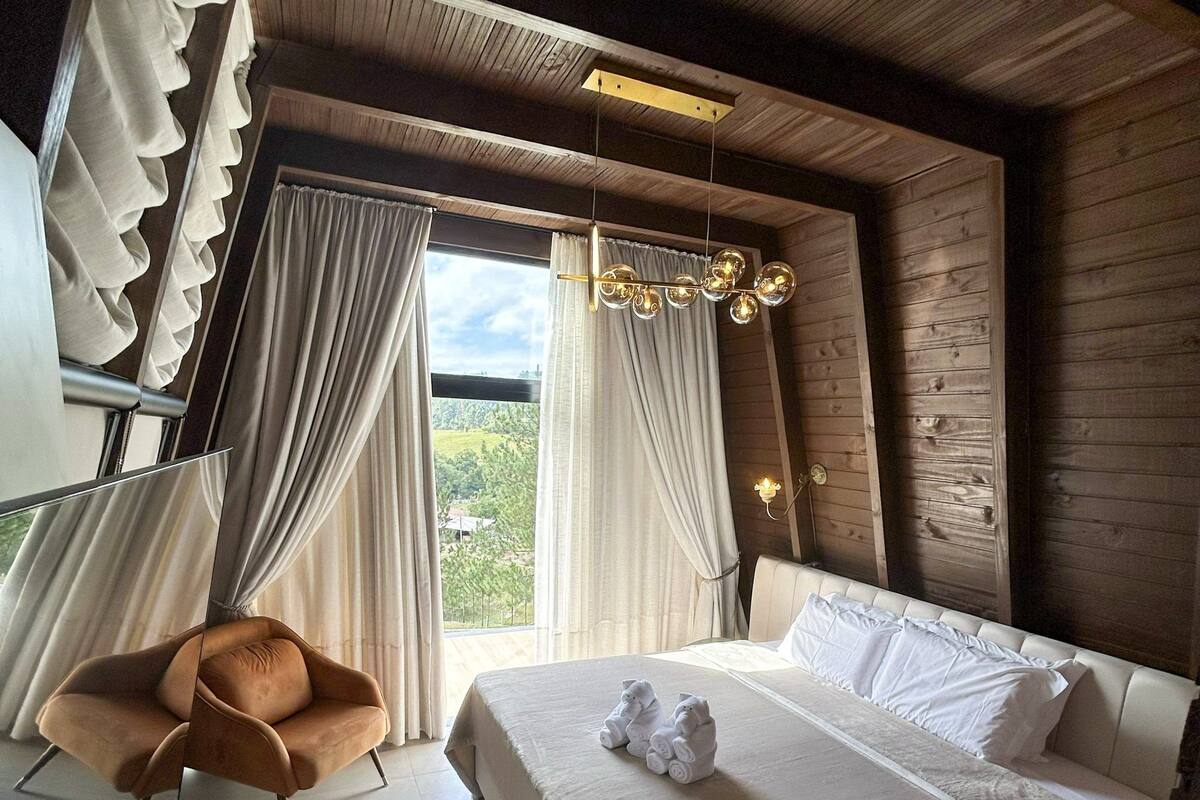 Una camera da letto con un letto, una sedia e una finestra con tende.