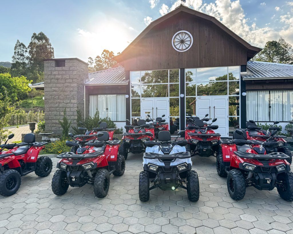 Un bâtiment doté d’un grand portail de garage et devant lequel sont stationnés plusieurs quads.