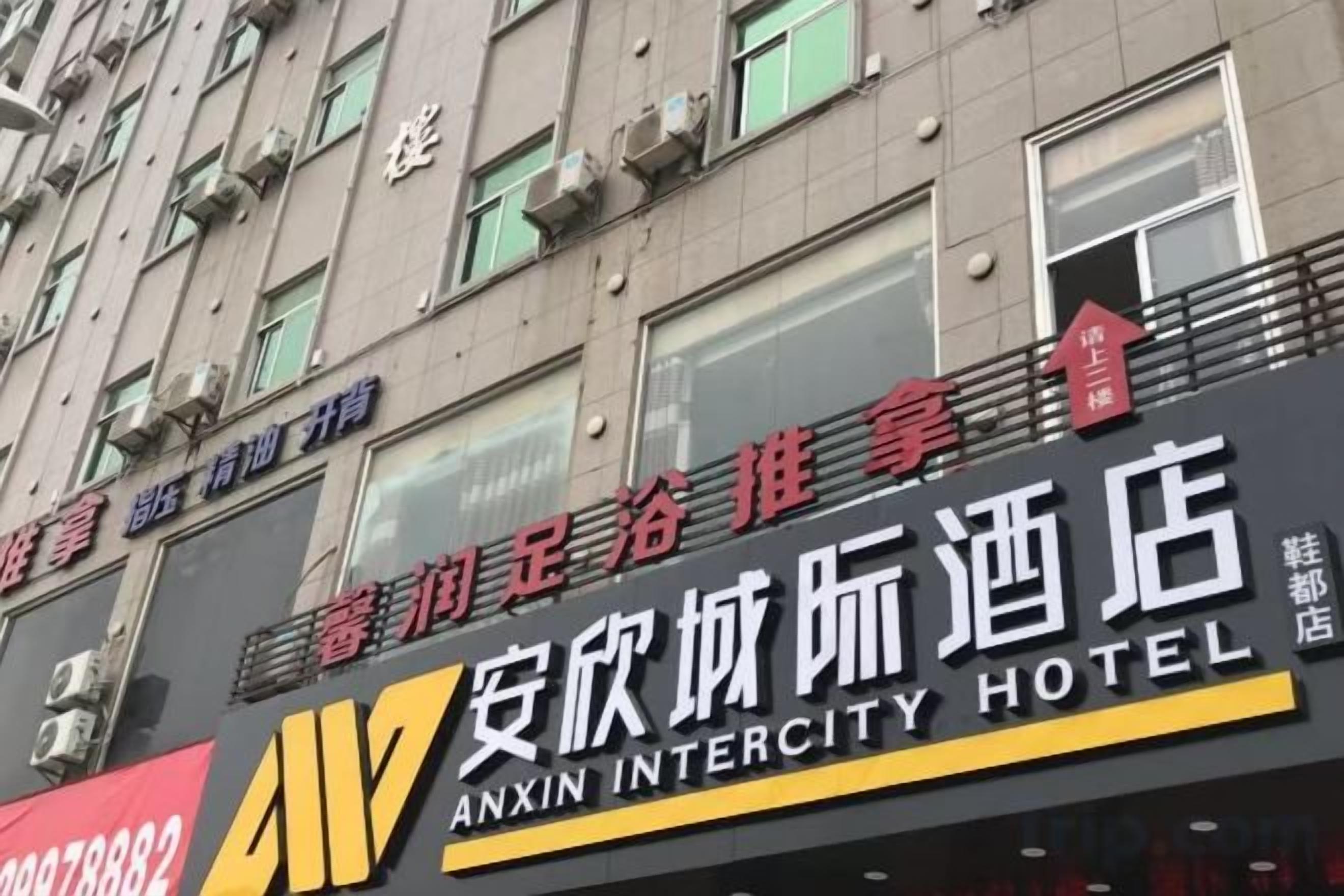 A hotel sign with the name 'Anxin Intercity Hotel' and a phone number.