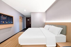 Een moderne hotelkamer met een groot bed, een tv aan de muur en een houten nachtkastje.