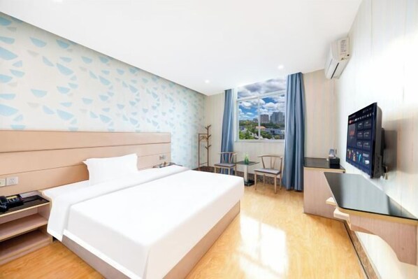 Een hotelkamer met een bed, bureau, stoel en televisie.