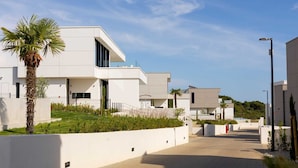 A modern residential building with a flat roof, large windows, and a paved walkway. - Villa Massima Prima with Pool (Ugljan)