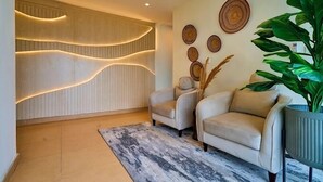 Een moderne woonkamer met twee banken, een grote potplant en decoratieve muurkunst.