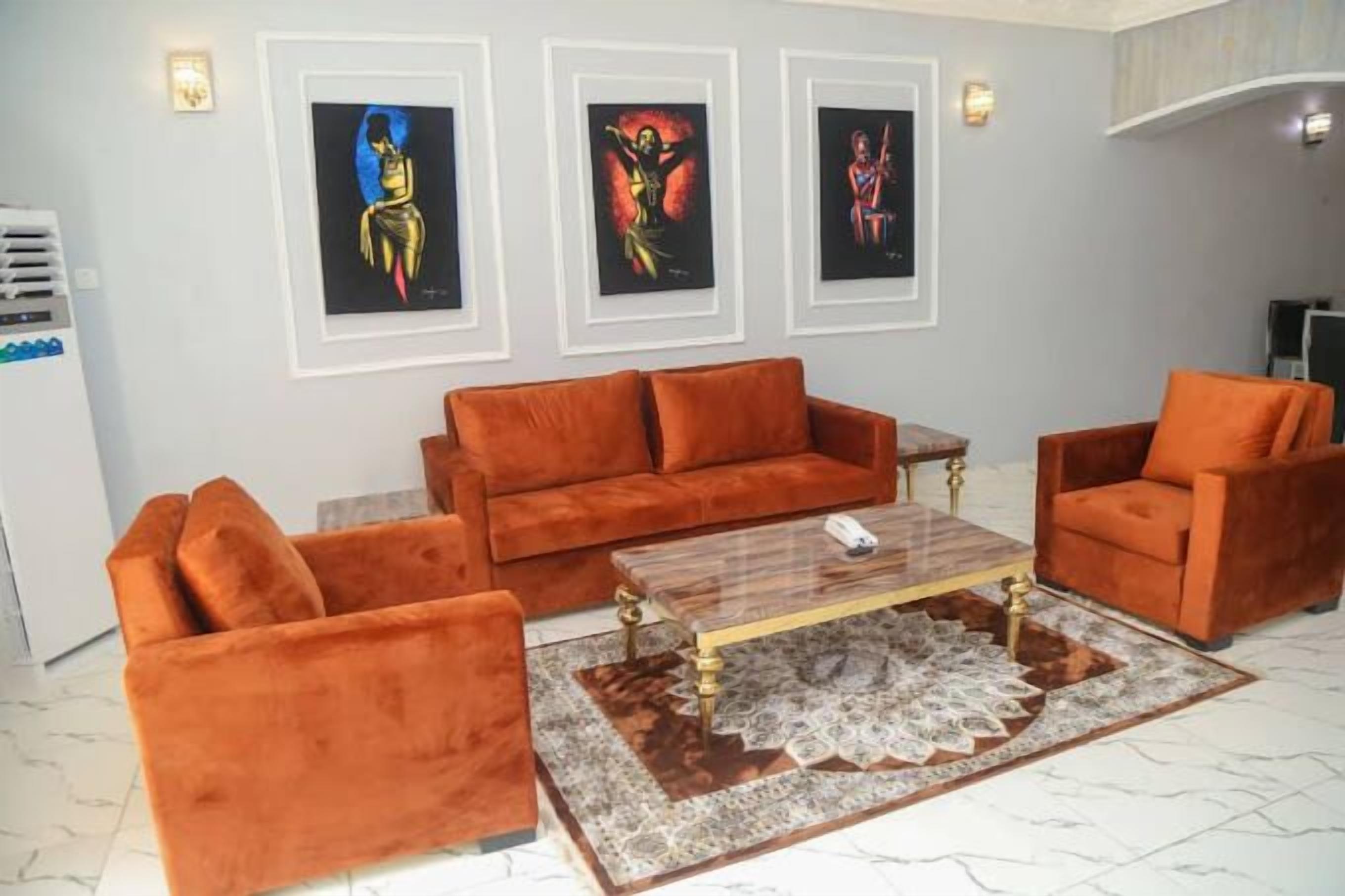 A living room with a sofa set, coffee table, and artwork on the wall.