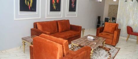 A living room with a sofa set, a coffee table, and artwork on the wall.