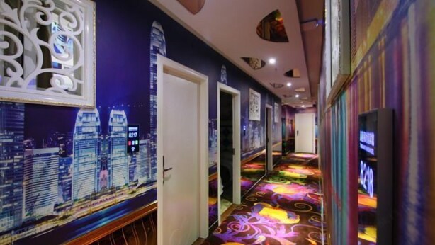 A hallway with a cityscape mural, a colorful carpet, and a mirrored wall. - Fujimengge Hotel Shanghai (Shanghai)