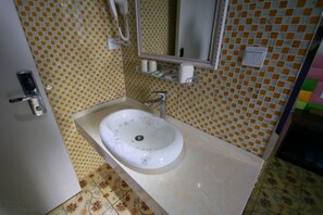 Casa de banho com lavatório, espelho e paredes revestidas a azulejos.