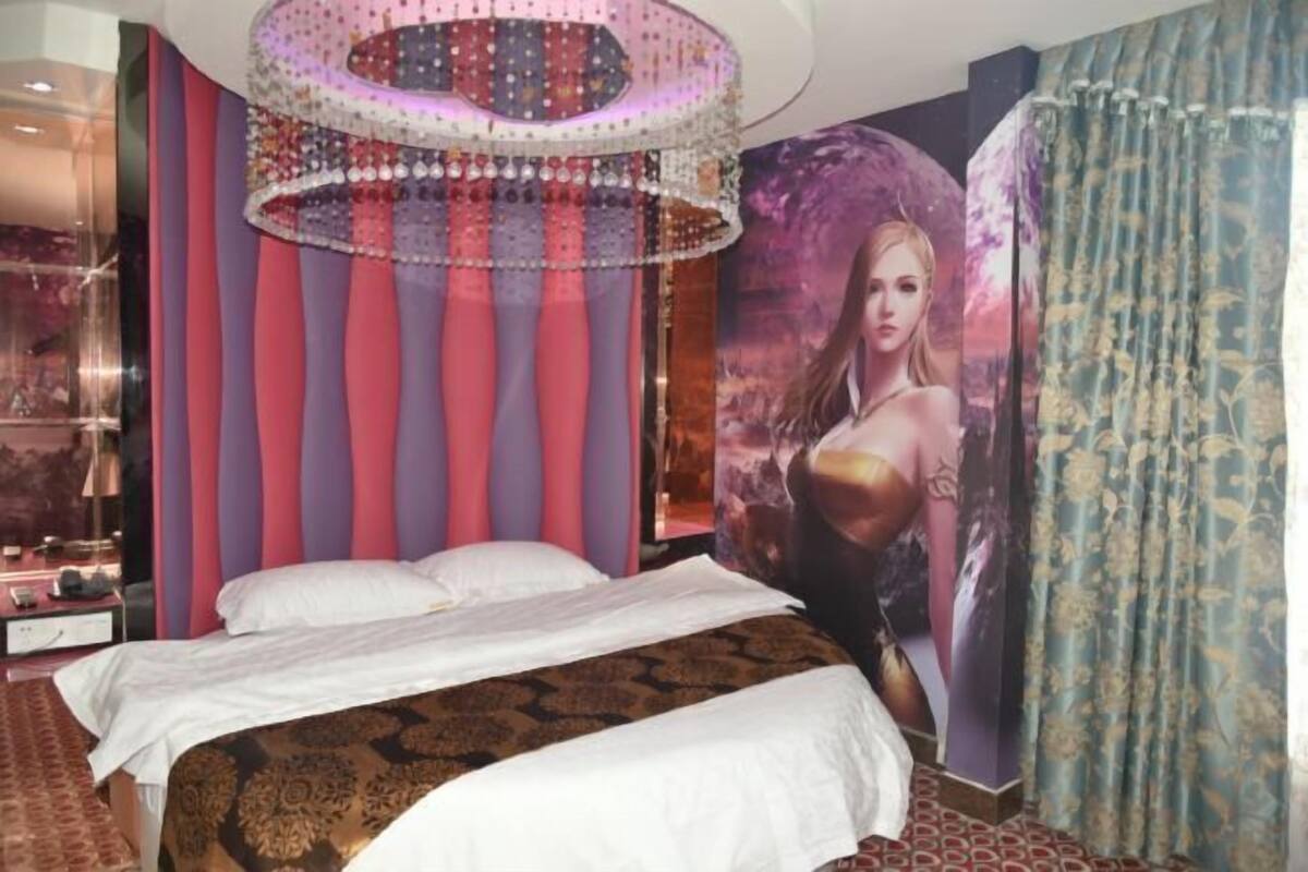 A bedroom with a bed, striped walls, a chandelier, and a large poster.