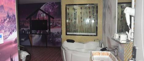 A bathroom with a large bathtub, a mirror, and a shower area.