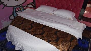 Uma cama com colcha estampada, cabeceira estofada vermelha e decoração de parede com tema Hello Kitty.