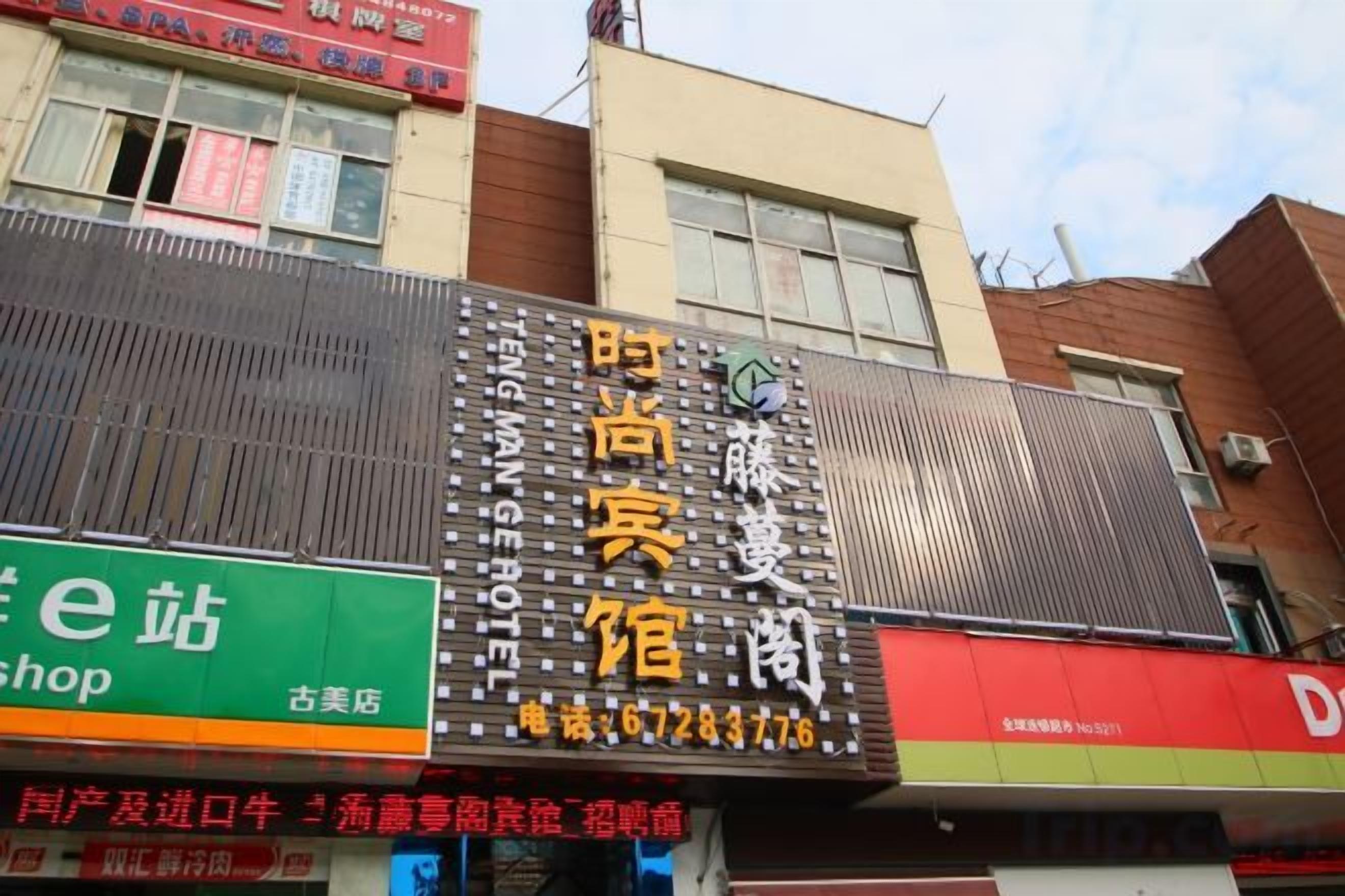 Un edificio con varios letreros, incluyendo uno de hotel y otro de tienda.