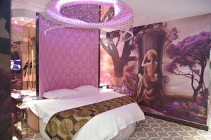 Un dormitorio con una cama, un gran mural en la pared y una lámpara en el techo.
