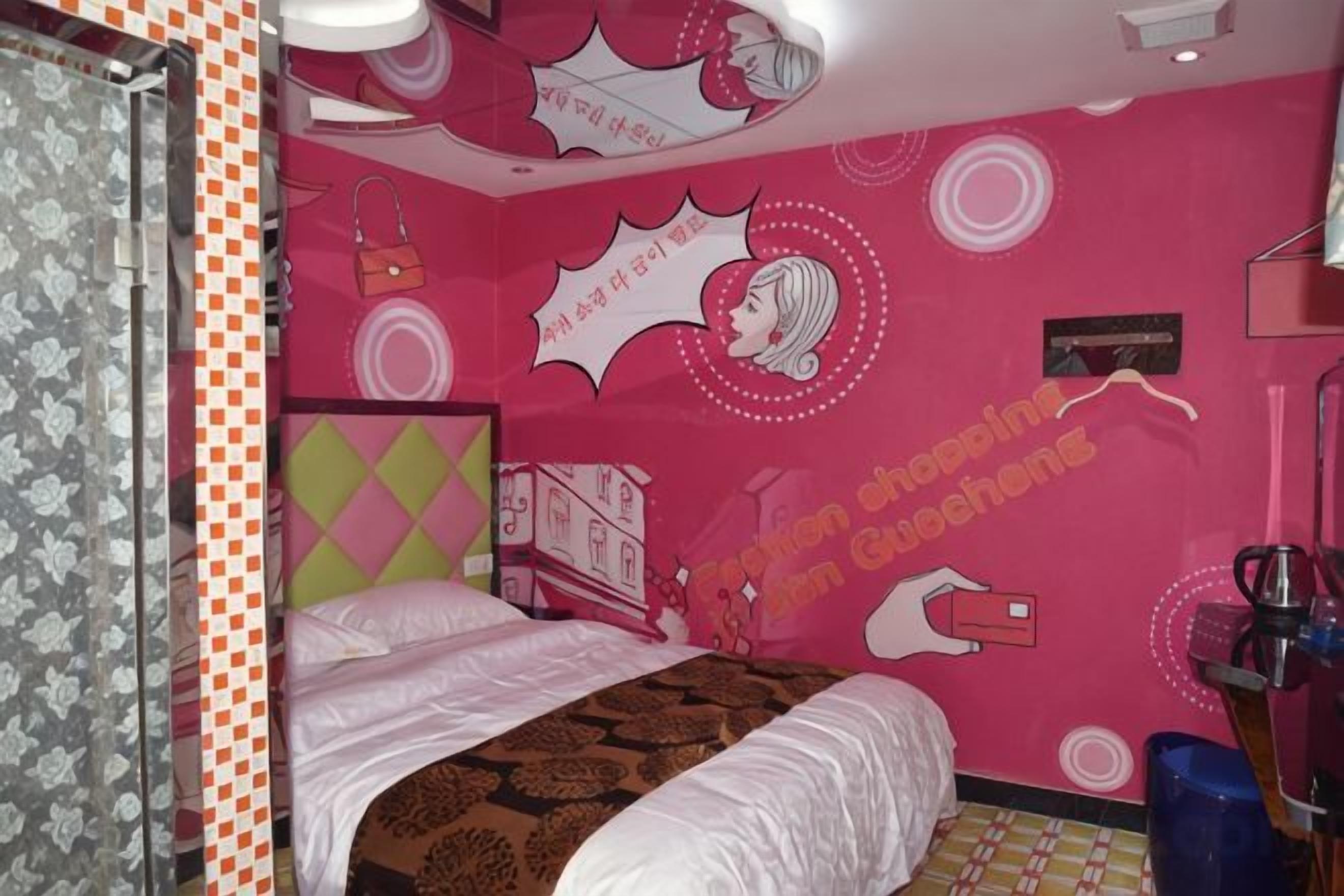 A bedroom with a bed, a dresser, a mirror, and a wall with text and graphics.