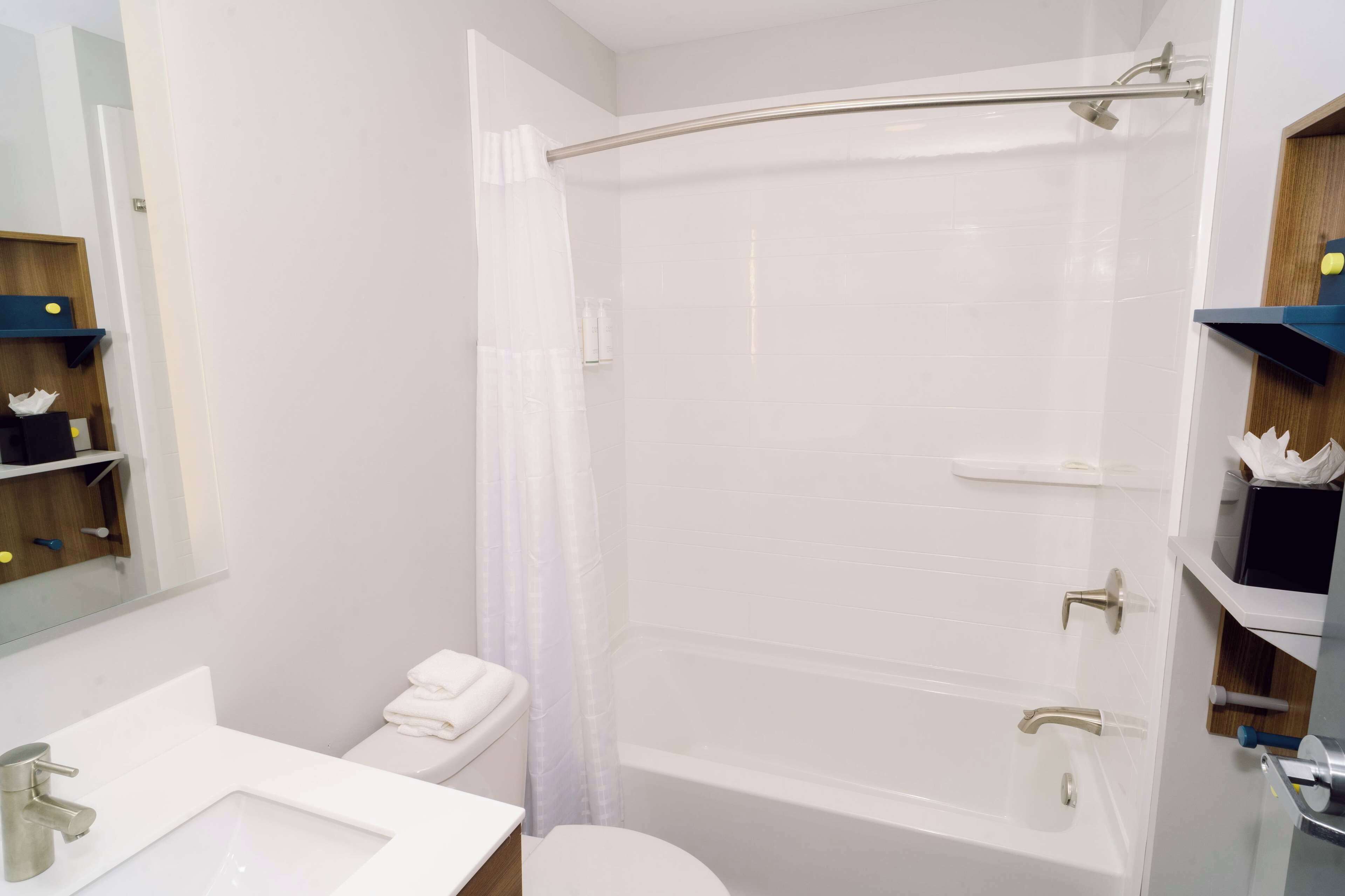 Un baño moderno con lavamanos, inodoro y bañera blancos.