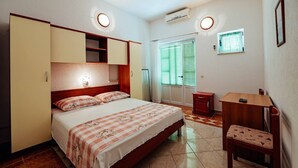 A bedroom with a bed, bedside tables, a desk, and a chair.