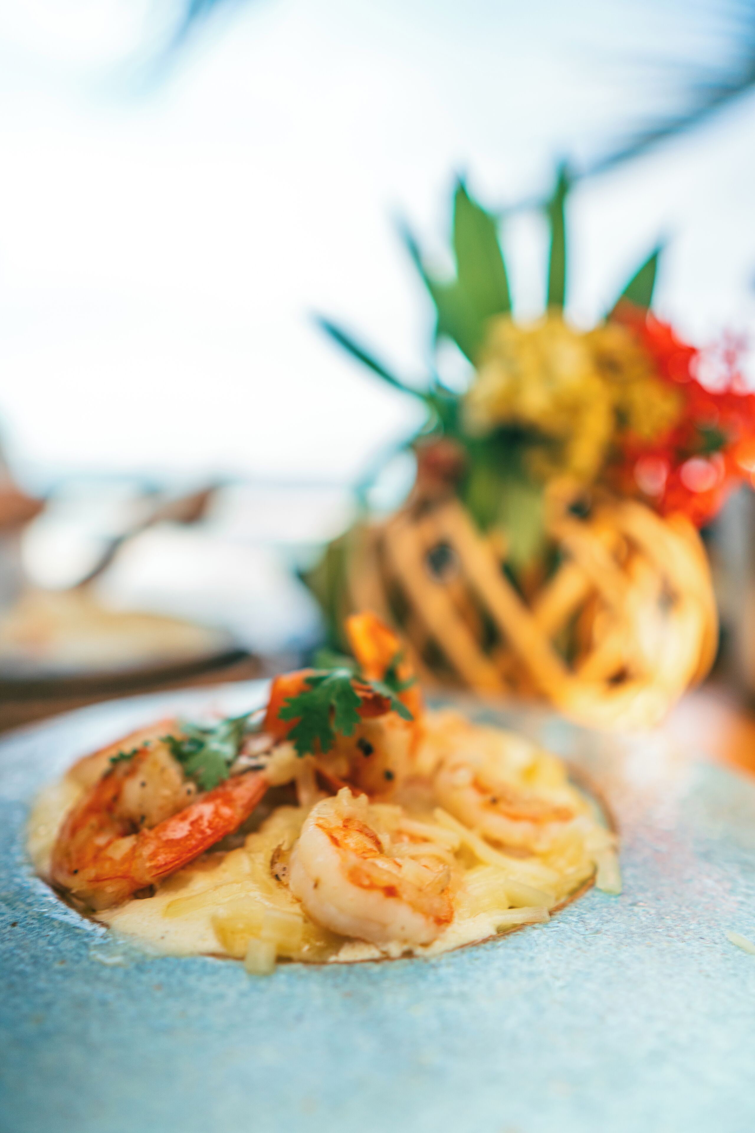 A plate with shrimp and a pineapple garnish.