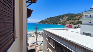 A coastal view with a beach, buildings, and a hilly landscape. - Beachfront Apartment, Sea View, Garage, 2 Bedrooms, WI-FI, Cable TV, NETFLIX etc. (Arraial do Cabo)