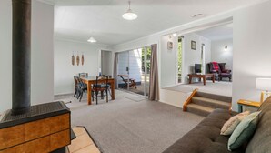 Amplia sala de estar con chimenea, una mesa de comedor y un sofá.