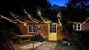 A brick building with a yellow door, a bench, and string lights. - QUINTA DE RIBAS - LA CLEF DES CHAMPS - AUTHENTIC LITTLE HOUSE (Vila cha do marao, amarante)