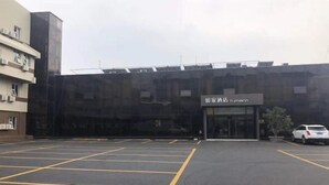 A parking lot with marked spaces and a building with a sign reading "Hotel Humenn". - Homeinn · neo (Qufu Jingxuan Middle Road Sankong) (Qufu)