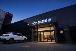 A hotel entrance with a modern facade, a car parked in front, and a clear sky. - Homeinn · neo (Qufu Jingxuan Middle Road Sankong) (Qufu)