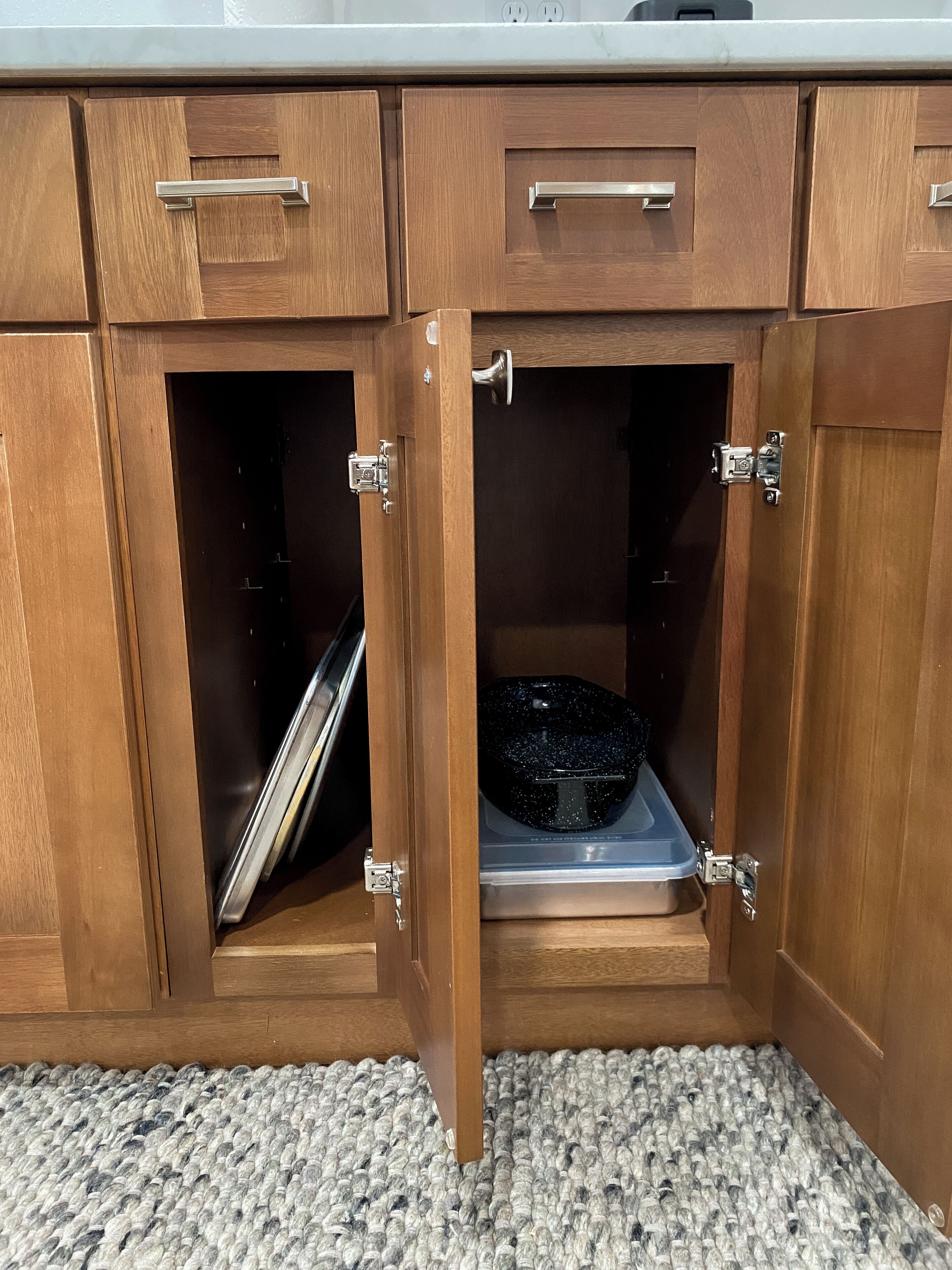 A kitchen with wooden cabinets, a countertop, and a built-in dishwasher.