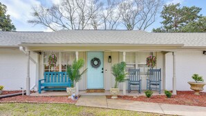 A house with a front porch, a blue door, and a wreath. There are two blue chairs and two potted plants on the porch. - 2 Mi to Shore: Modern Retreat in Fort Walton Beach (Fort Walton Beach)