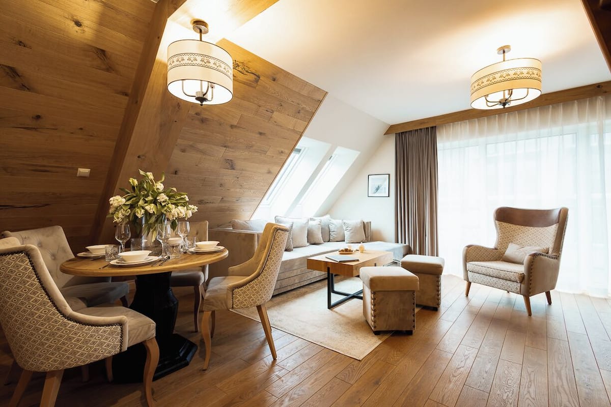 A modern living room with a wooden ceiling, a round dining table, and a sofa.