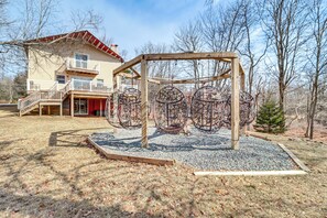 A two-story house with a balcony and a wooden play structure in the yard. - Fire Pit + Game Room: Spacious Poconos Retreat! (Long Pond)