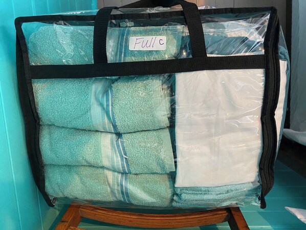 Un sac de rangement étiqueté « C complet » contenant des serviettes pliées.