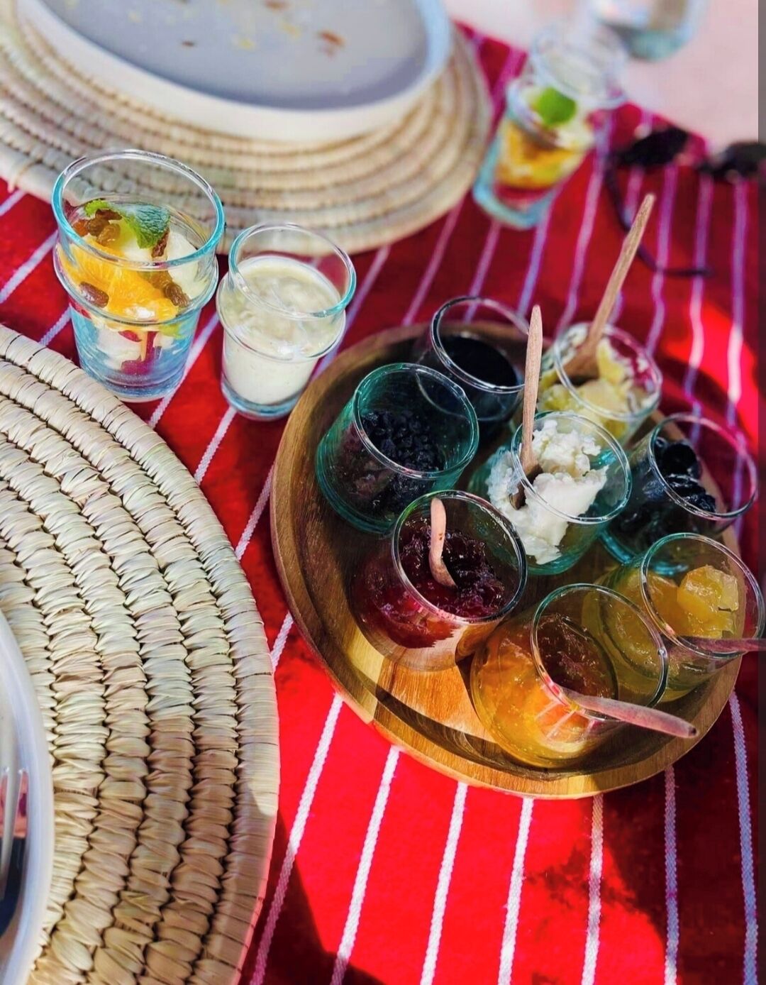 A table with various food items, including jars of preserves and a plate with different types of food.