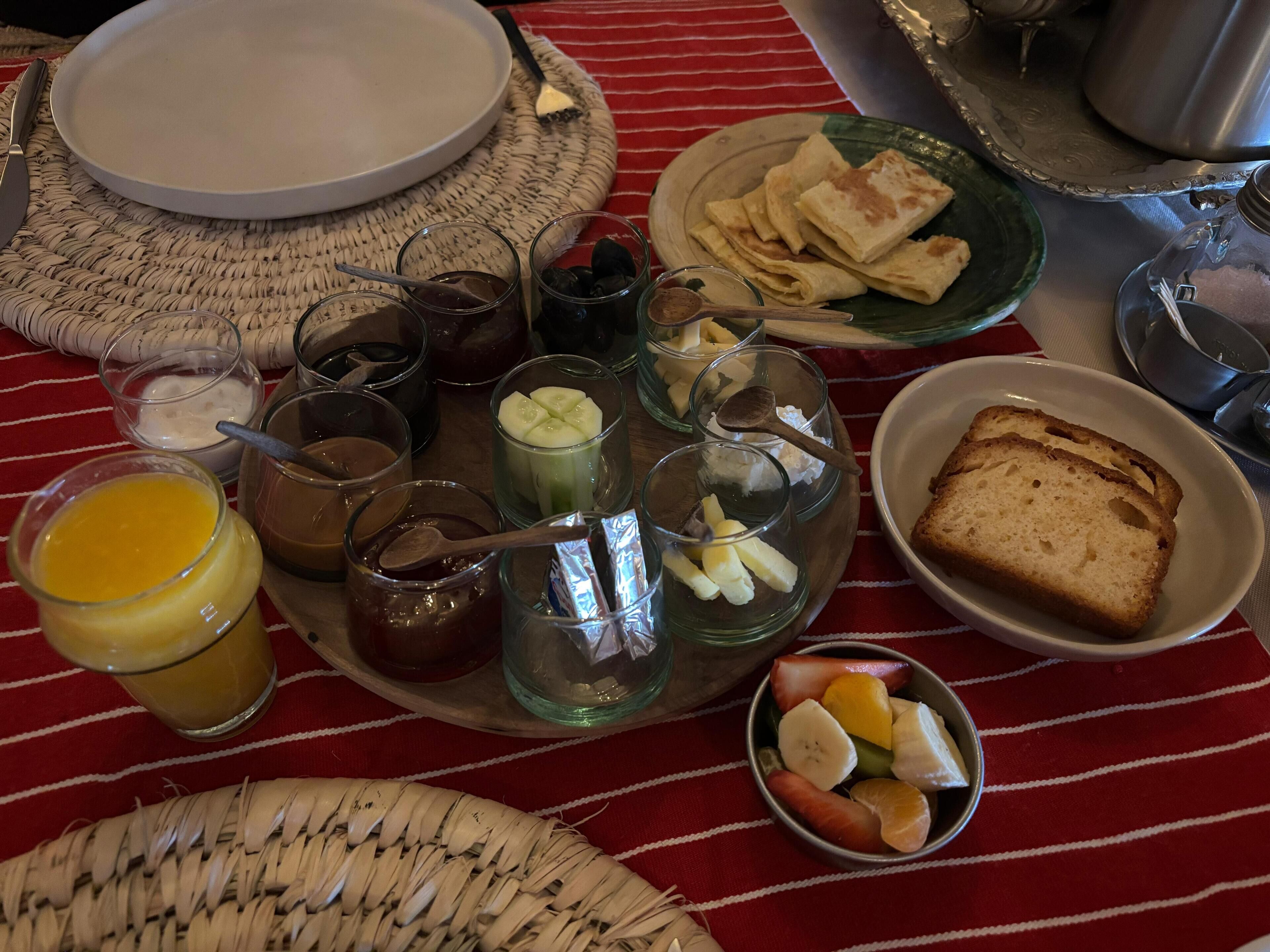 A breakfast setting with plates, bowls, and glasses of various foods and beverages.