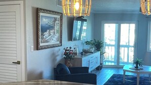 A kitchen with marble countertops, a sink, and a dining area with a table and chairs. There are pendant lights above the kitchen counter. - 2-bedroom Condo in lovely Siesta Key Beach minimum 1 Month 55 & over Second Unit (Sarasota)